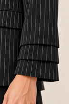 Blazer de raya diplomática en negro y gris, detalle del tejido y los puños
