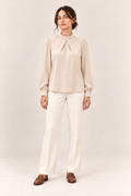 Blusa satinada con cuello alto y pliegues en marfil, vista frontal de estudio