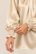 Blusa satinada en crudo, detalle del puño fruncido y volante