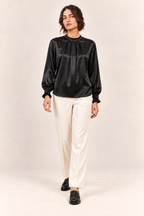 Blusa satinada en negro, vista frontal de estudio