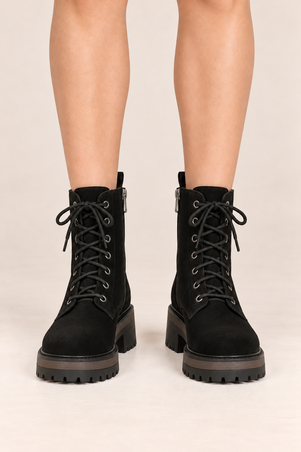 Botines de cordones con suela gruesa en negro, vista frontal de estudio