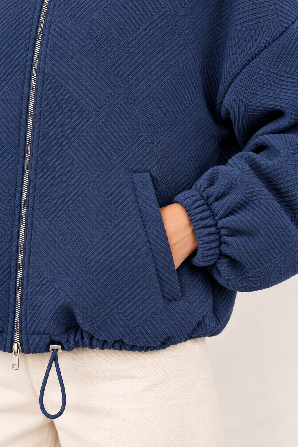 Chaqueta bomber de cuello alto en azul marino, detalle del tejido y el bolsillo