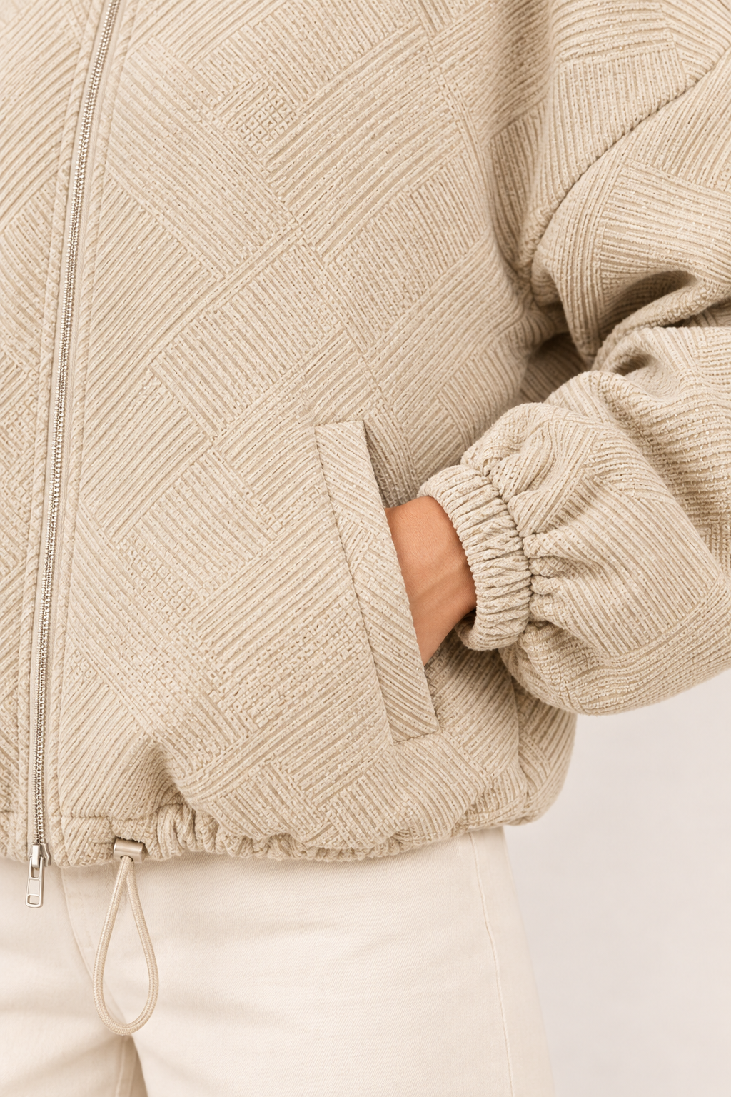Chaqueta bomber de cuello alto en caqui, detalle del tejido y el bolsillo