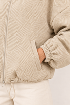 Chaqueta bomber de cuello alto en caqui, detalle del tejido y el bolsillo