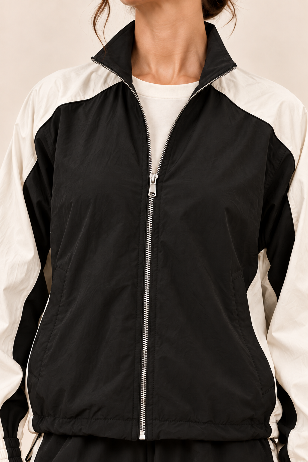 Conjunto deportivo con paneles a contraste en negro, detalle del cuello y la cremallera