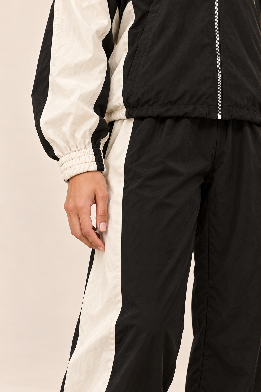 Conjunto deportivo con paneles a contraste en negro, detalle del puño y el panel a contraste