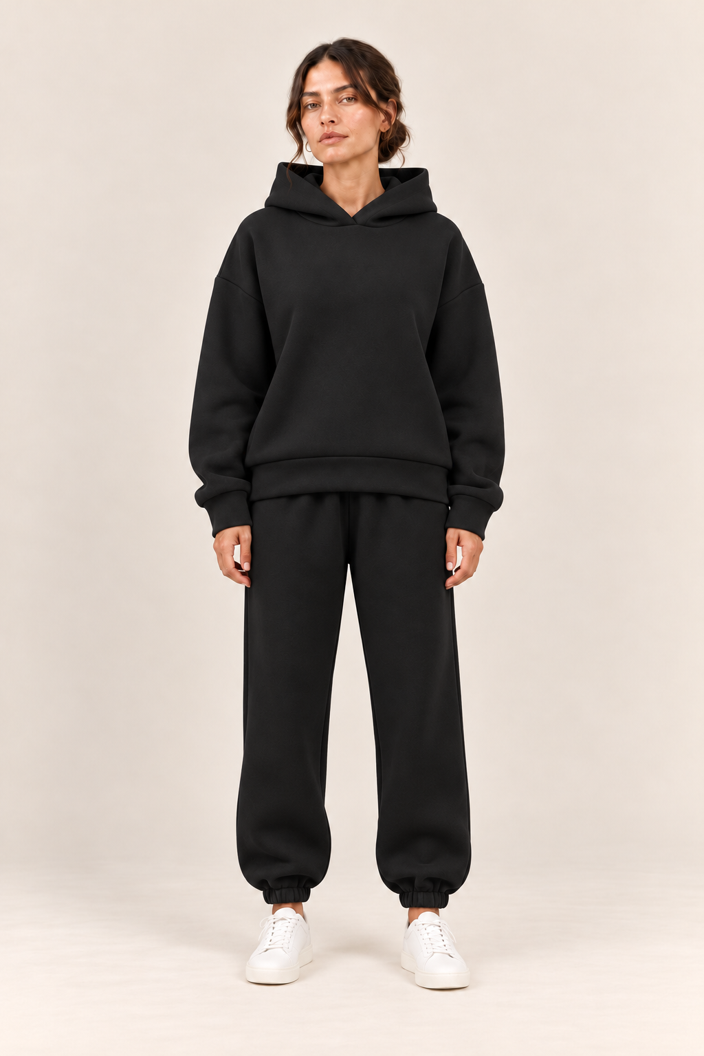 Conjunto con capucha de corte relajado en negro, vista frontal de estudio