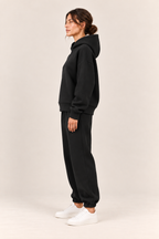 Conjunto con capucha de corte relajado en negro, vista lateral