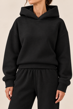 Conjunto con capucha de corte relajado en negro, detalle de la capucha