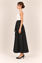 Falda larga de pinzas con bolsillos en negro, vista lateral de perfil