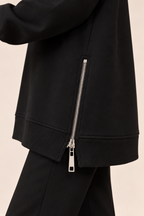 Jersey con cremallera lateral en negro, detalle de la cremallera lateral
