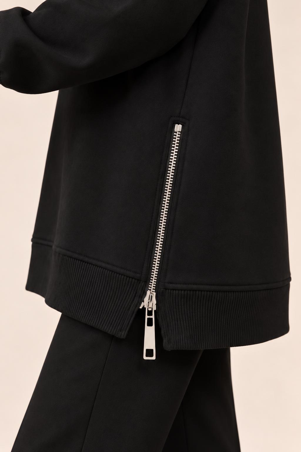 Jersey con cremallera lateral en negro, detalle de la cremallera lateral