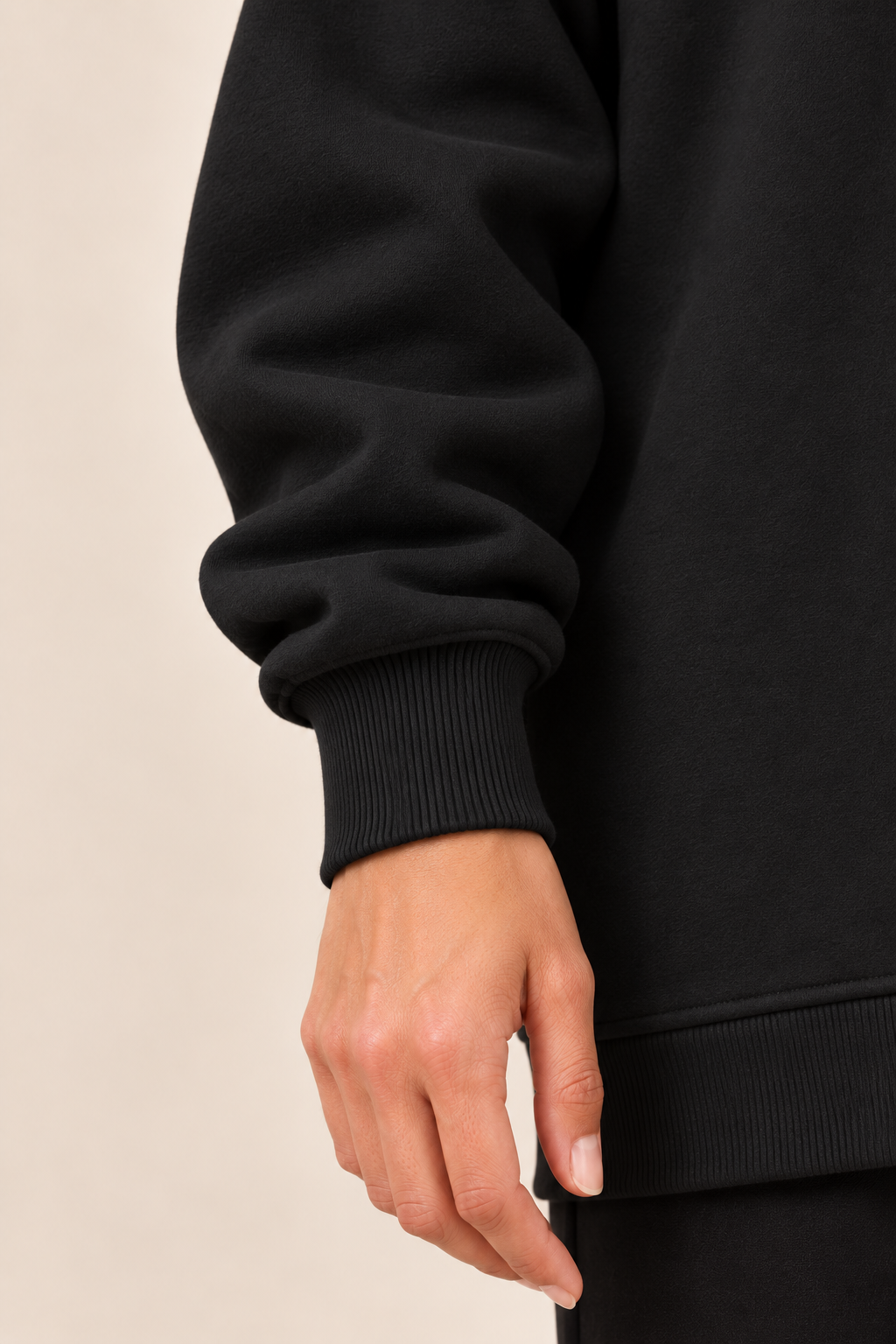 Jersey con cremallera lateral en negro, detalle del puño