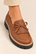 Mocasines con lazo y flecos en marrón, detalle del lazo y los flecos