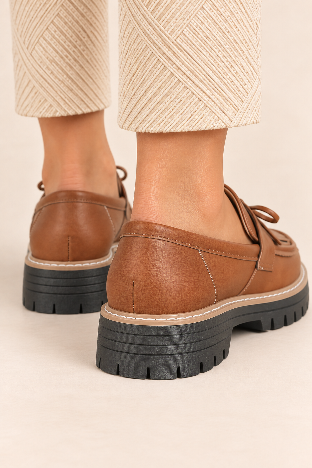 Mocasines con lazo y flecos en marrón, detalle del talón y la suela