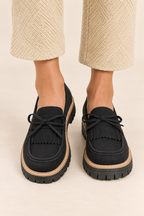 Mocasines con lazo y flecos en negro, vista frontal de estudio