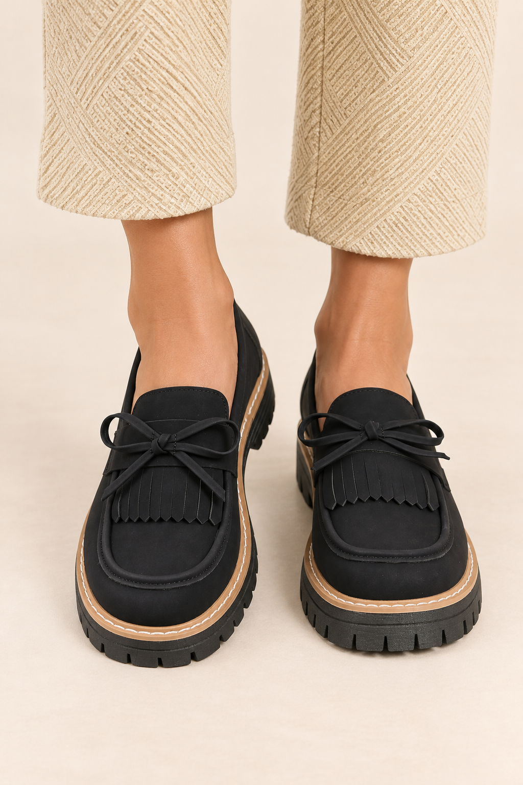 Mocasines con lazo y flecos en negro, vista frontal de estudio
