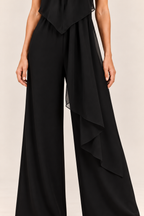 Mono halter con lazada al cuello en negro, detalle del panel asimétrico